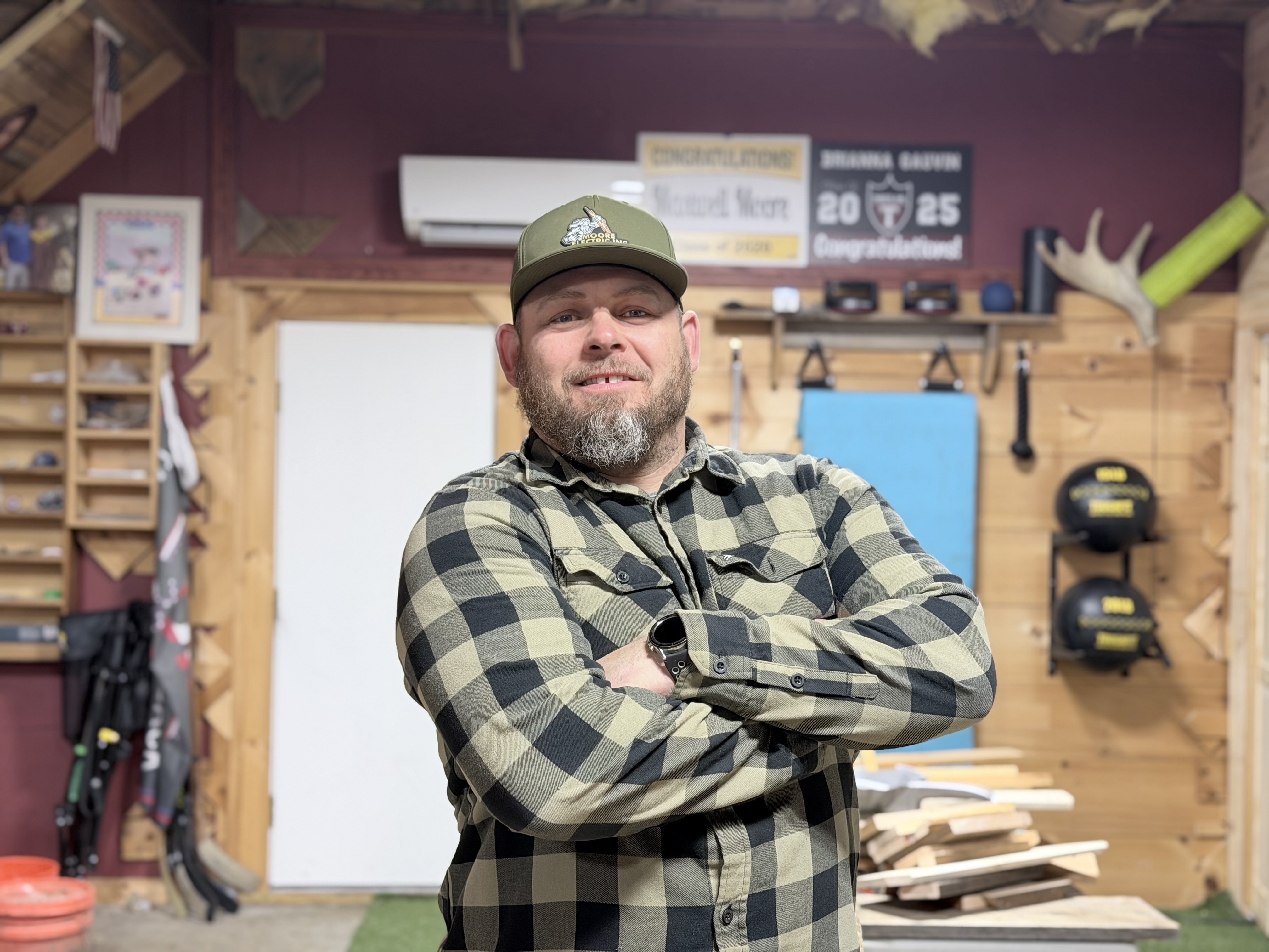 Brenden Moore, Master Electrician and Owner of Moore Electric Inc., standing confidently in a workshop, showcasing expertise in electrical services for renovations.