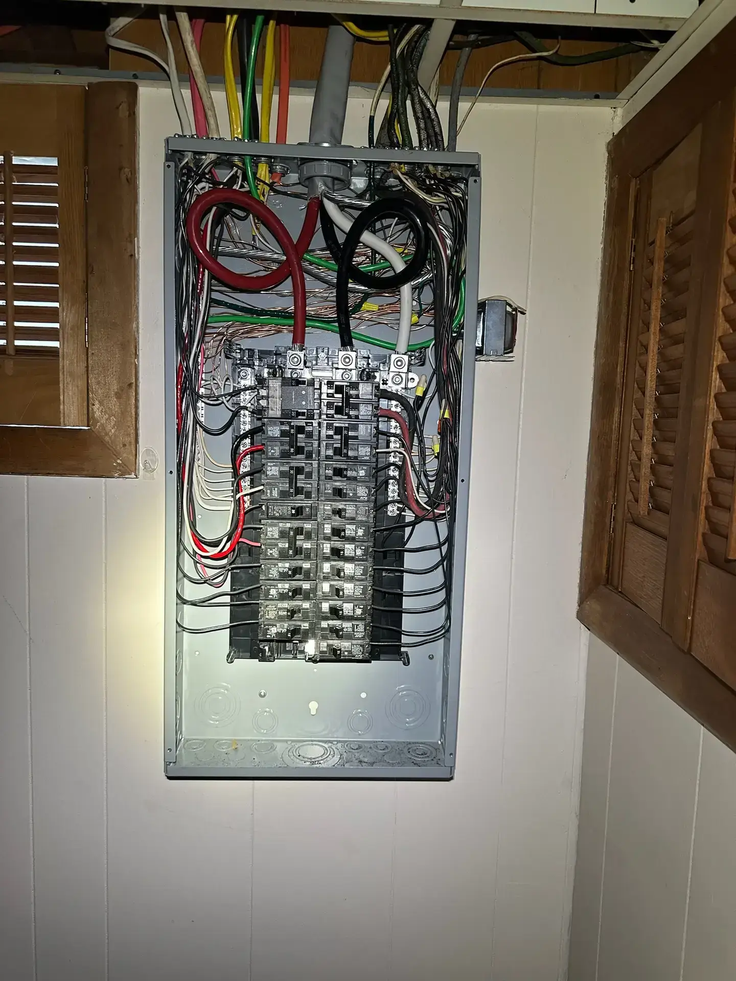 Electrical panel with multiple circuit breakers and colorful wiring, showcasing a residential electrical system upgrade, relevant to Moore Electric's panel installation services in Plaistow, NH.