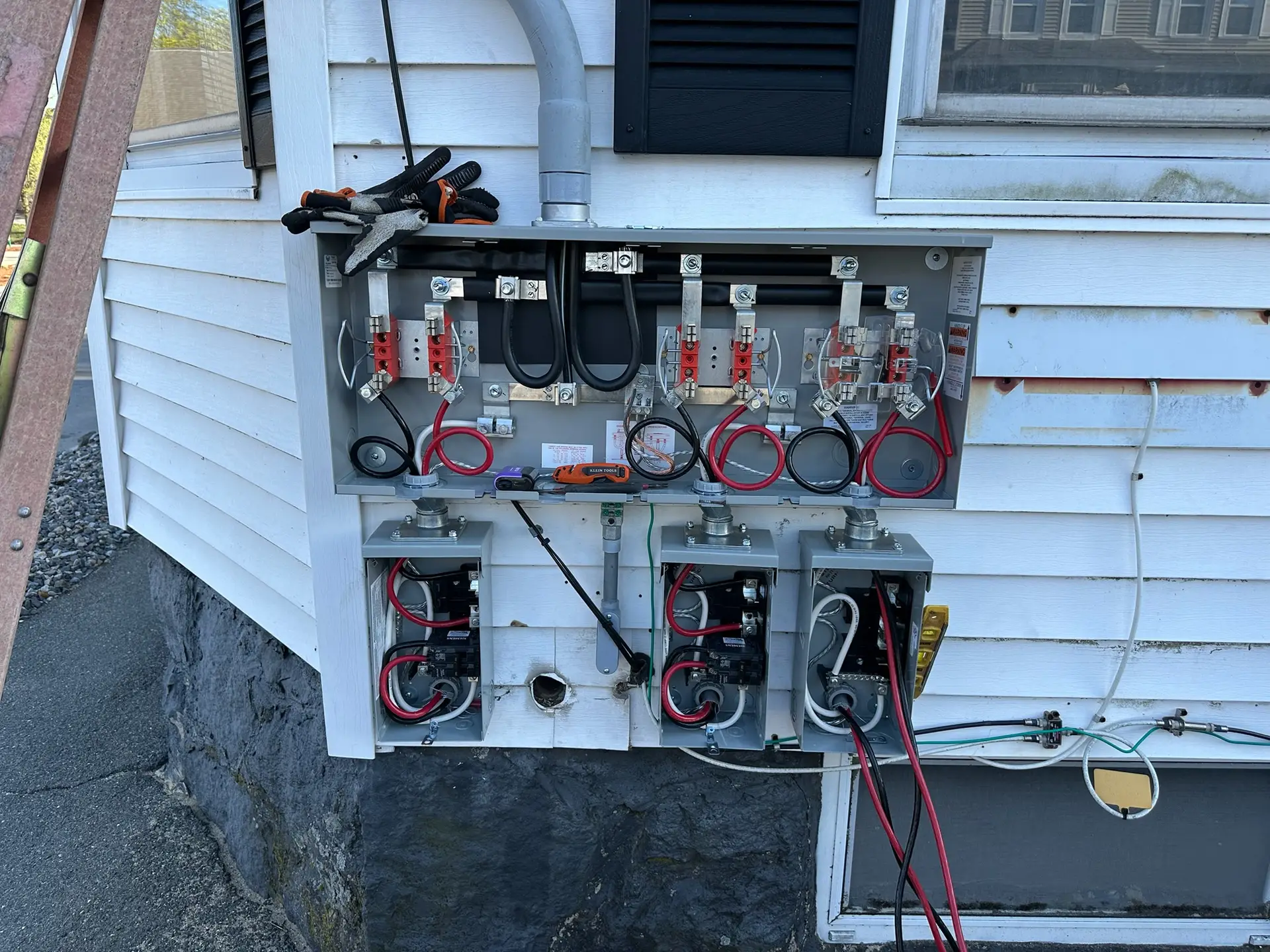 Electrical panel upgrade installation with multiple circuit breakers, wiring, and meter base, showcasing Moore Electric's service in Plaistow, NH.