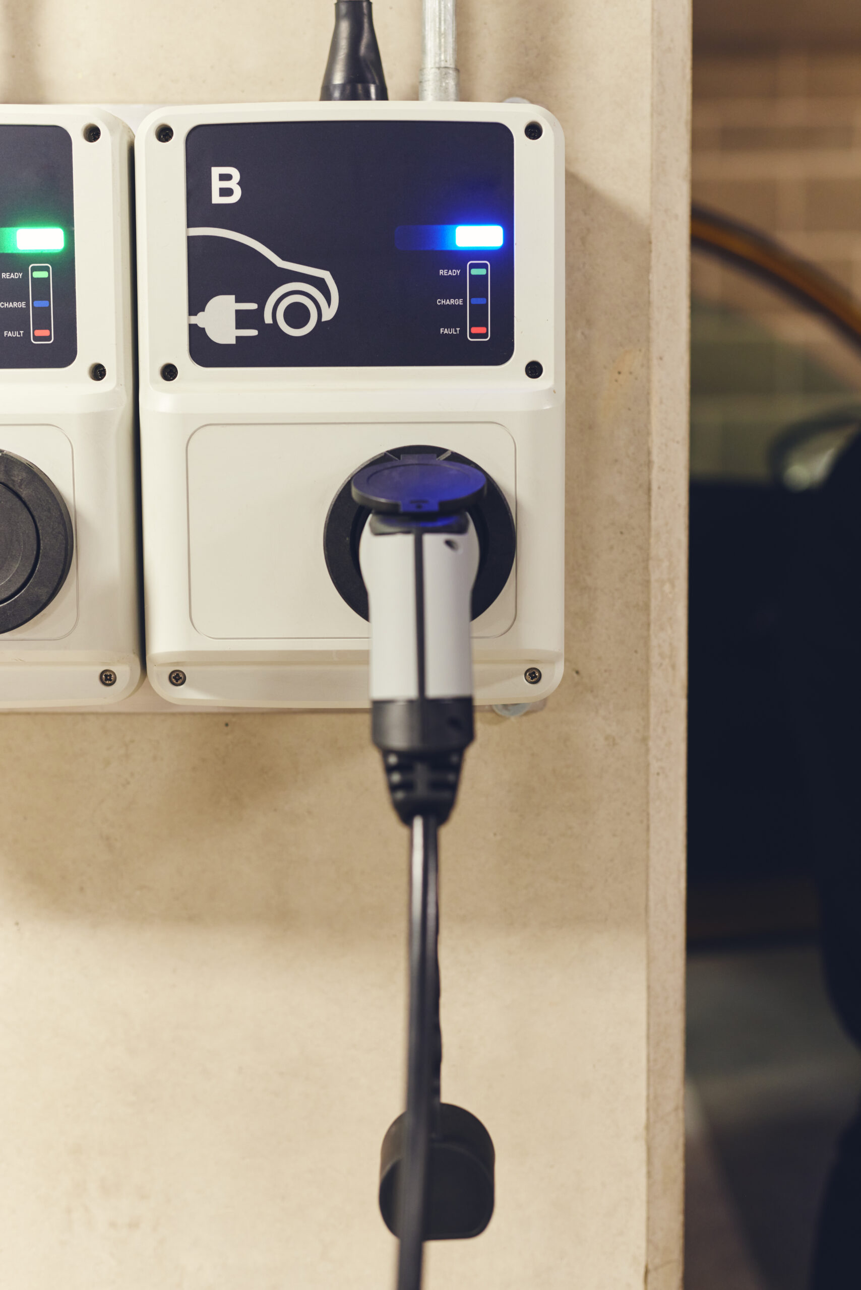 Level 2 EV charger installed in a home garage, displaying charging status indicators and a connected charging plug for electric vehicles.