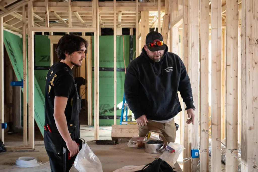 Electrician and apprentice inspecting new home wiring in Plaistow, NH.